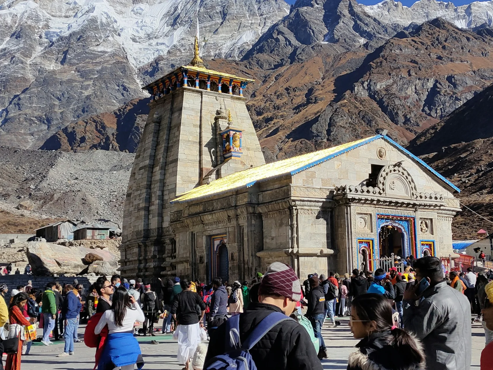 Pilgrims at Kedarnath Temple with Himalayan mountains behind