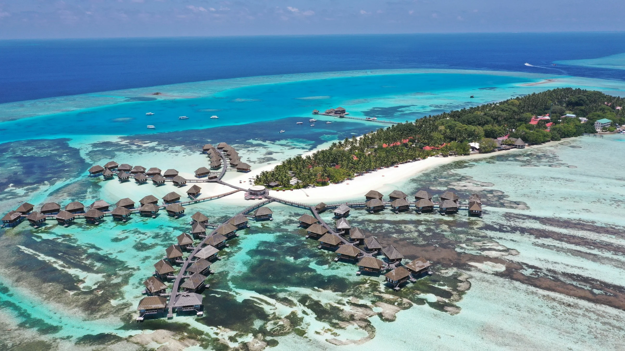 Aerial view of overwater villas and the turquoise lagoon at Club Med Kani in the Maldives